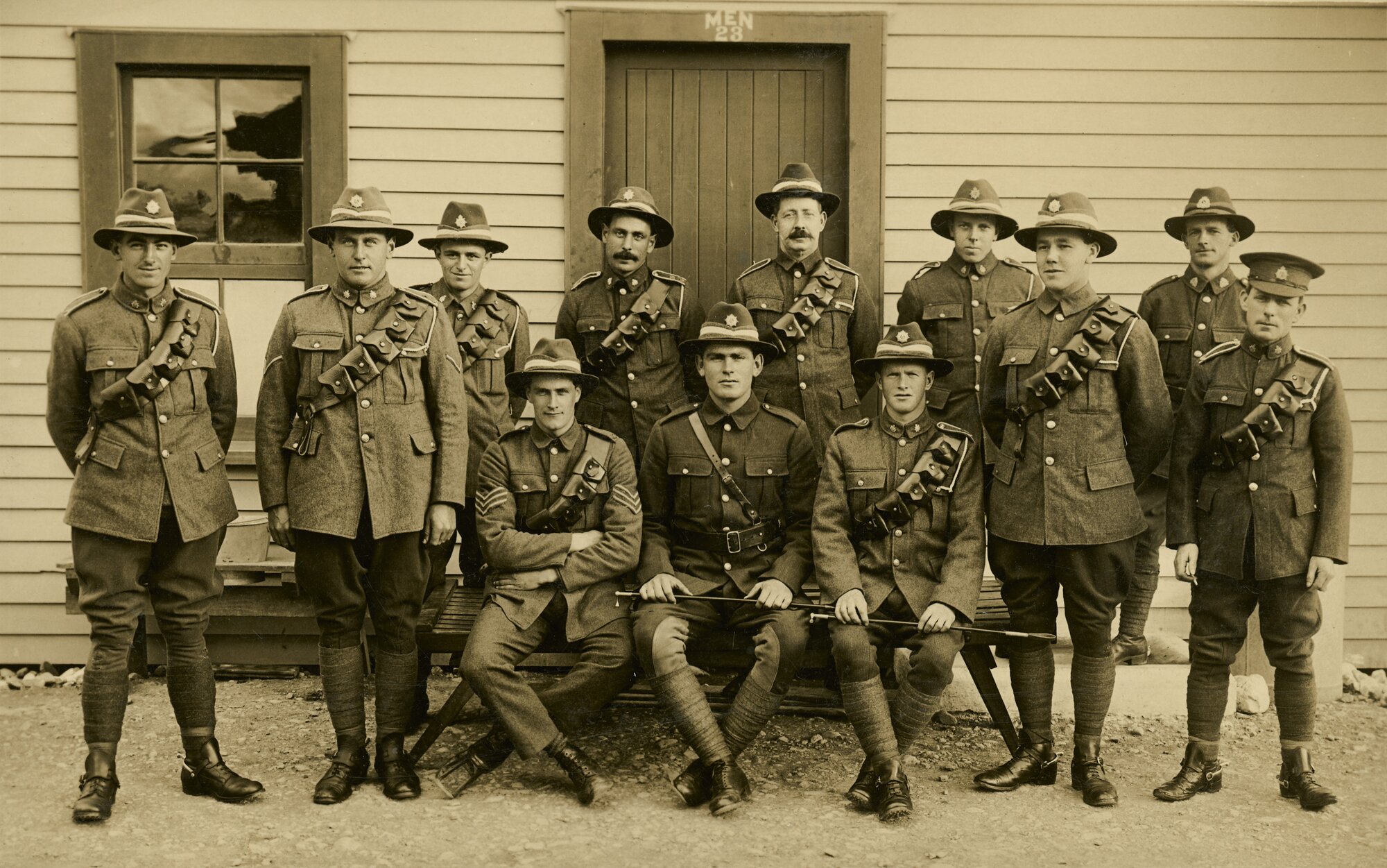 Soldiers in uniform outside barracks; badges unidentified.