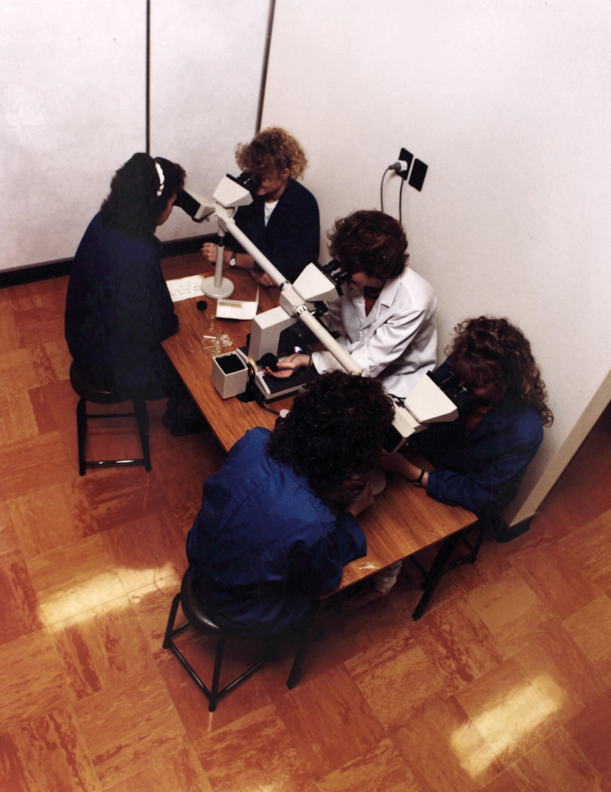 Central Institute of Technology in operation; unidentified laboratory(?); instructor with microscope sharing view with students.