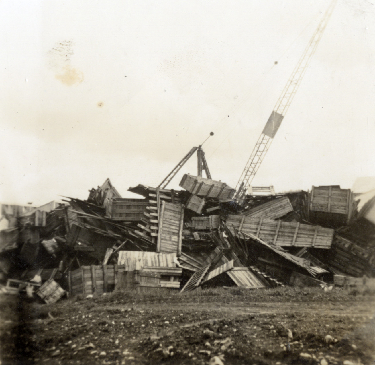 Dunlop factory construction; scrap timber; Scotch-derrick crane used in building the factory in background.