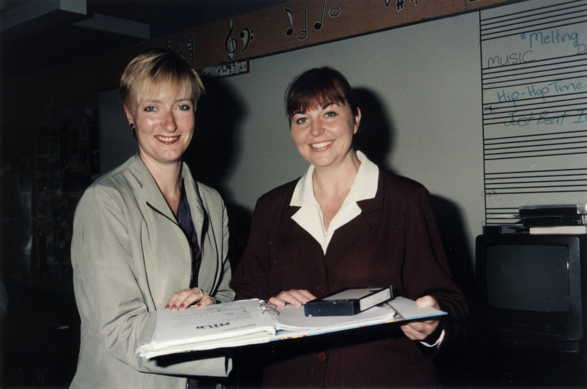 Teachers Tracey McLennan and Ellie Watts with video and proof of their book 'The Melting Pot'.