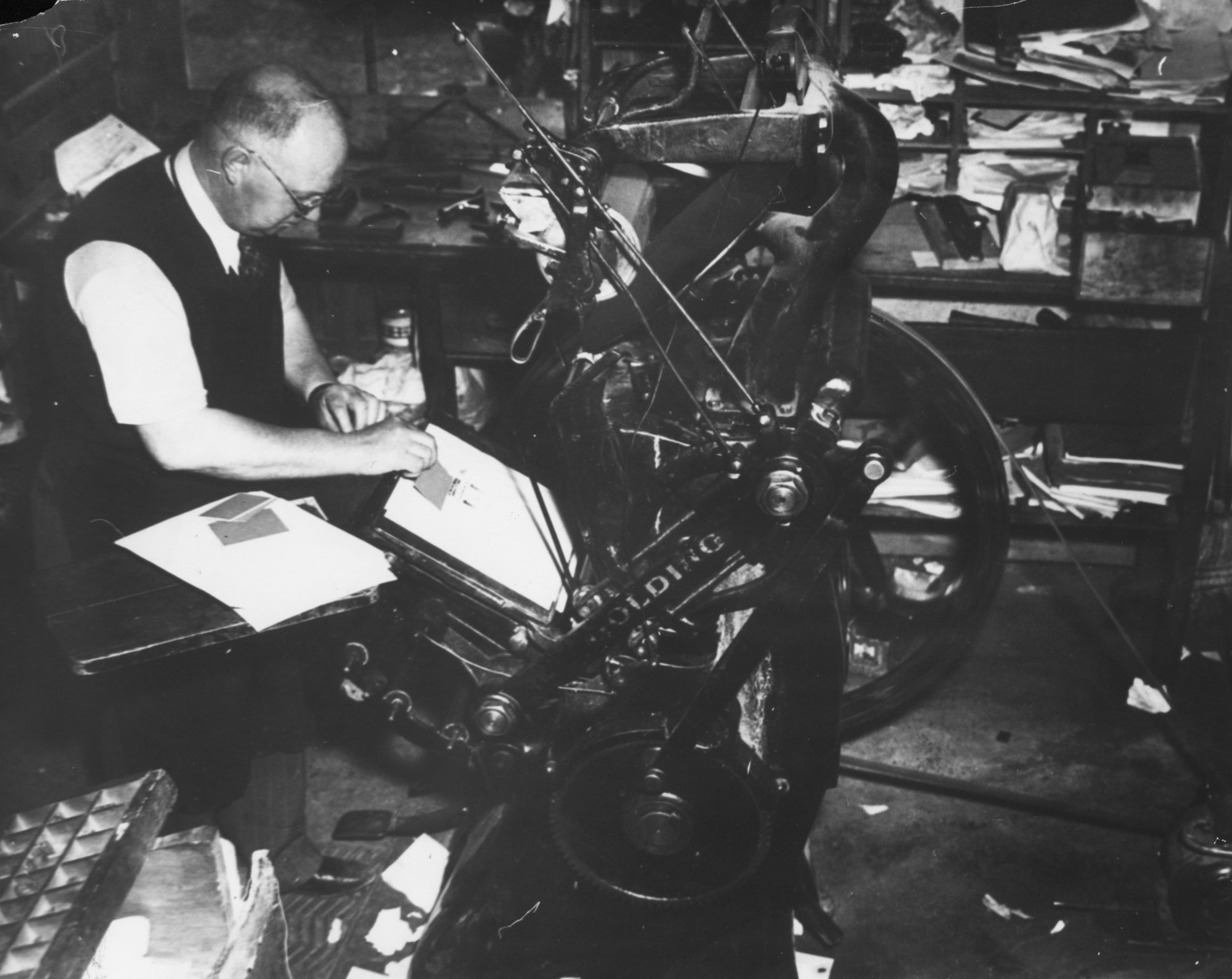 Ralph Ashford in the Upper Hutt Printing Co., with an early press.
