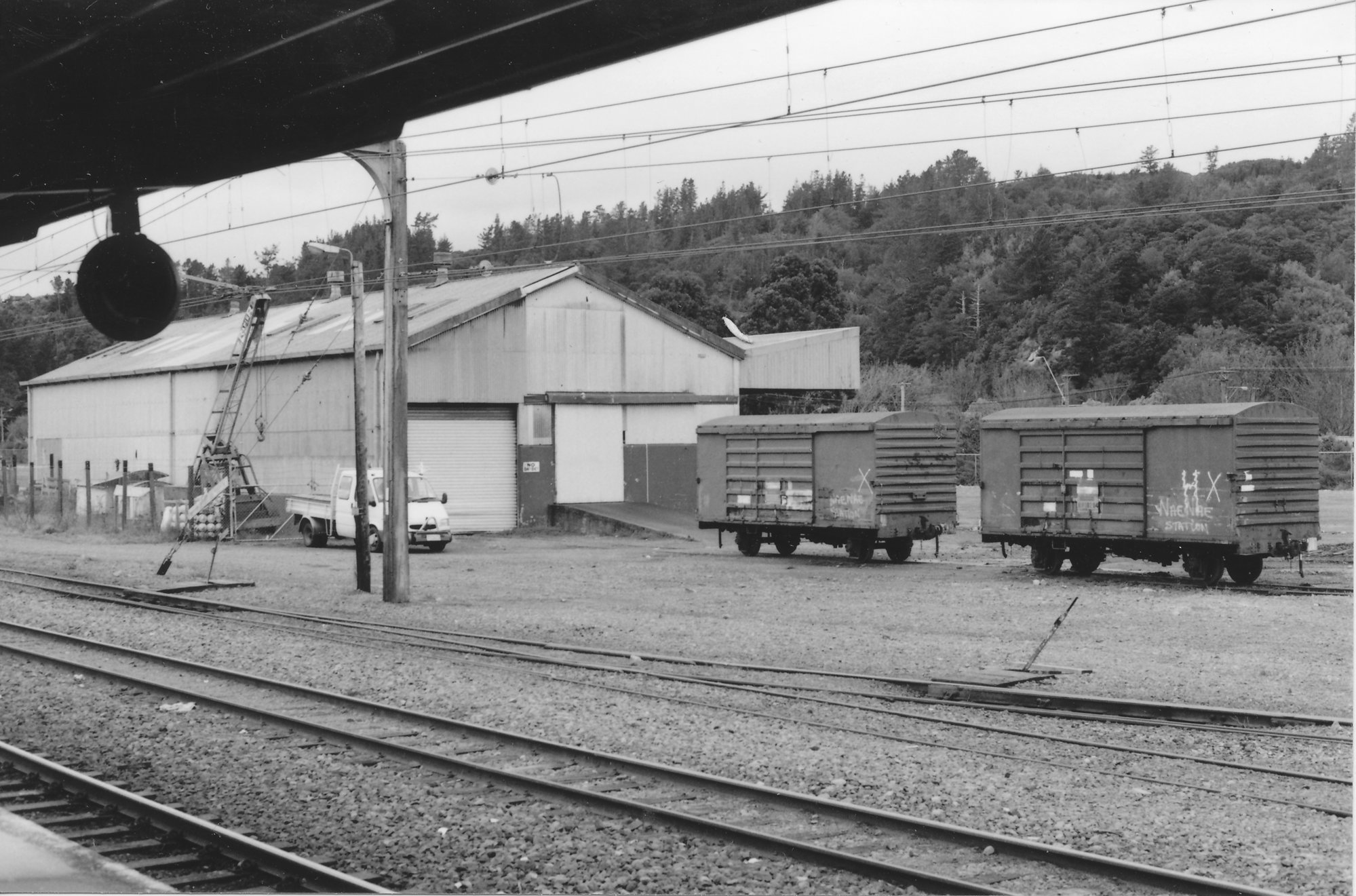 Upper Hutt railway station; goods shed and wagons, seen from the station platform - 1990s.