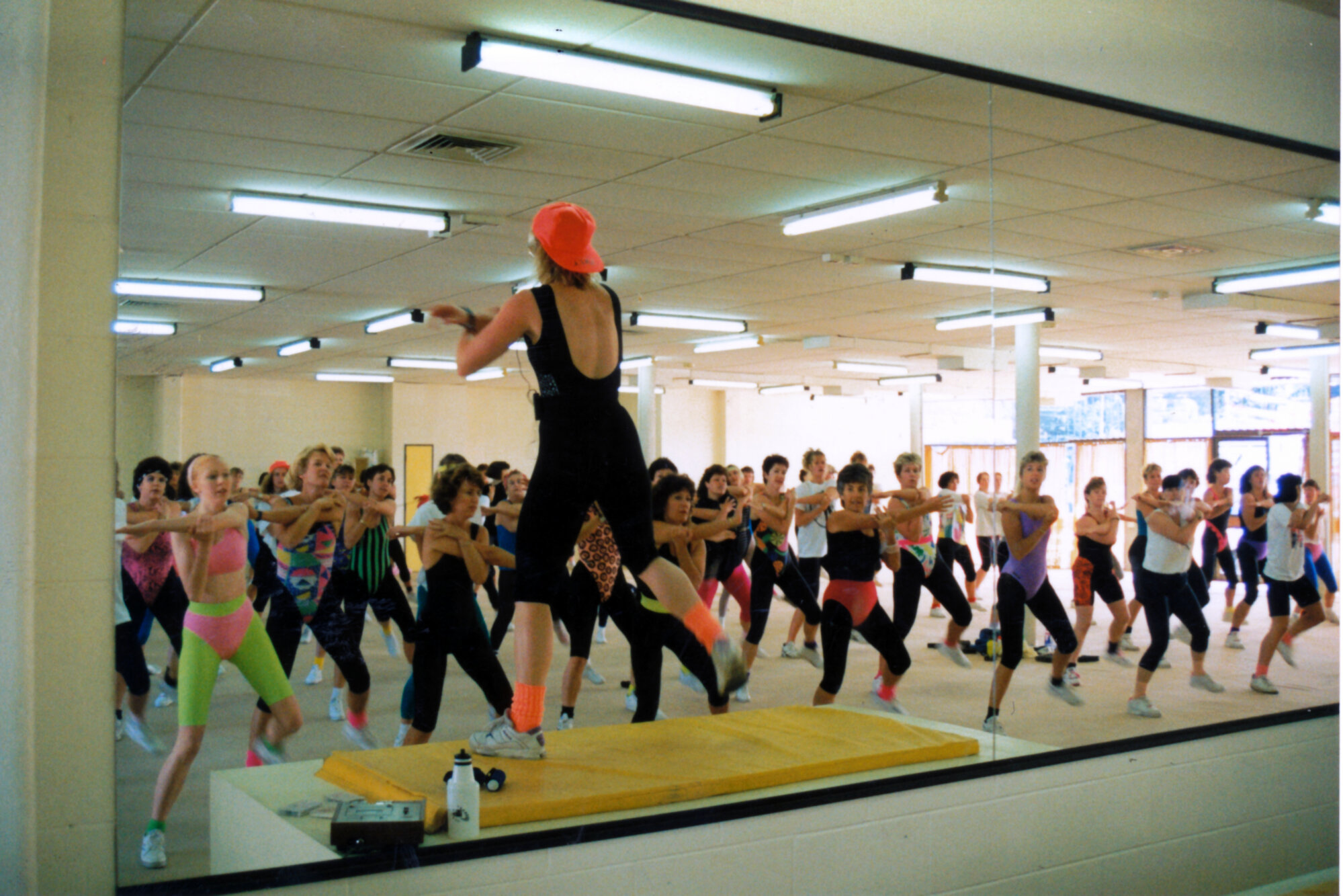 YMCA gymnasium; instructor Debbie Houston and 150 low-impact aerobics participants.