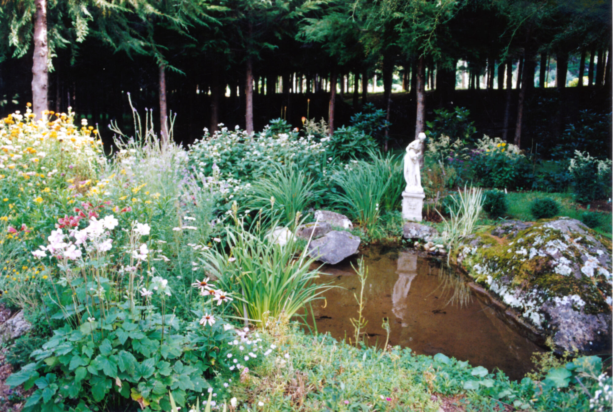 Efil Doog Garden of Art to open in 1995; perennials surround a pond.