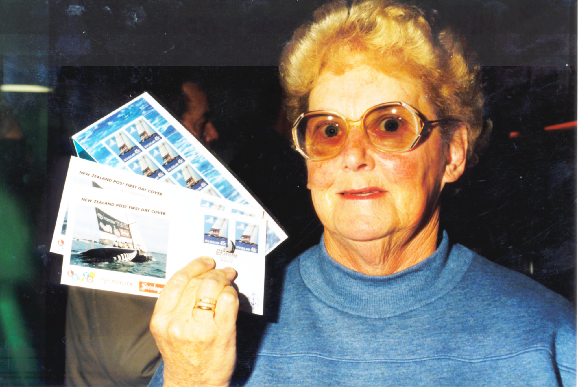 America's Cup stamps on sale; Doris Scarlett with first-day covers and 10-stamp 'sheetlet'
