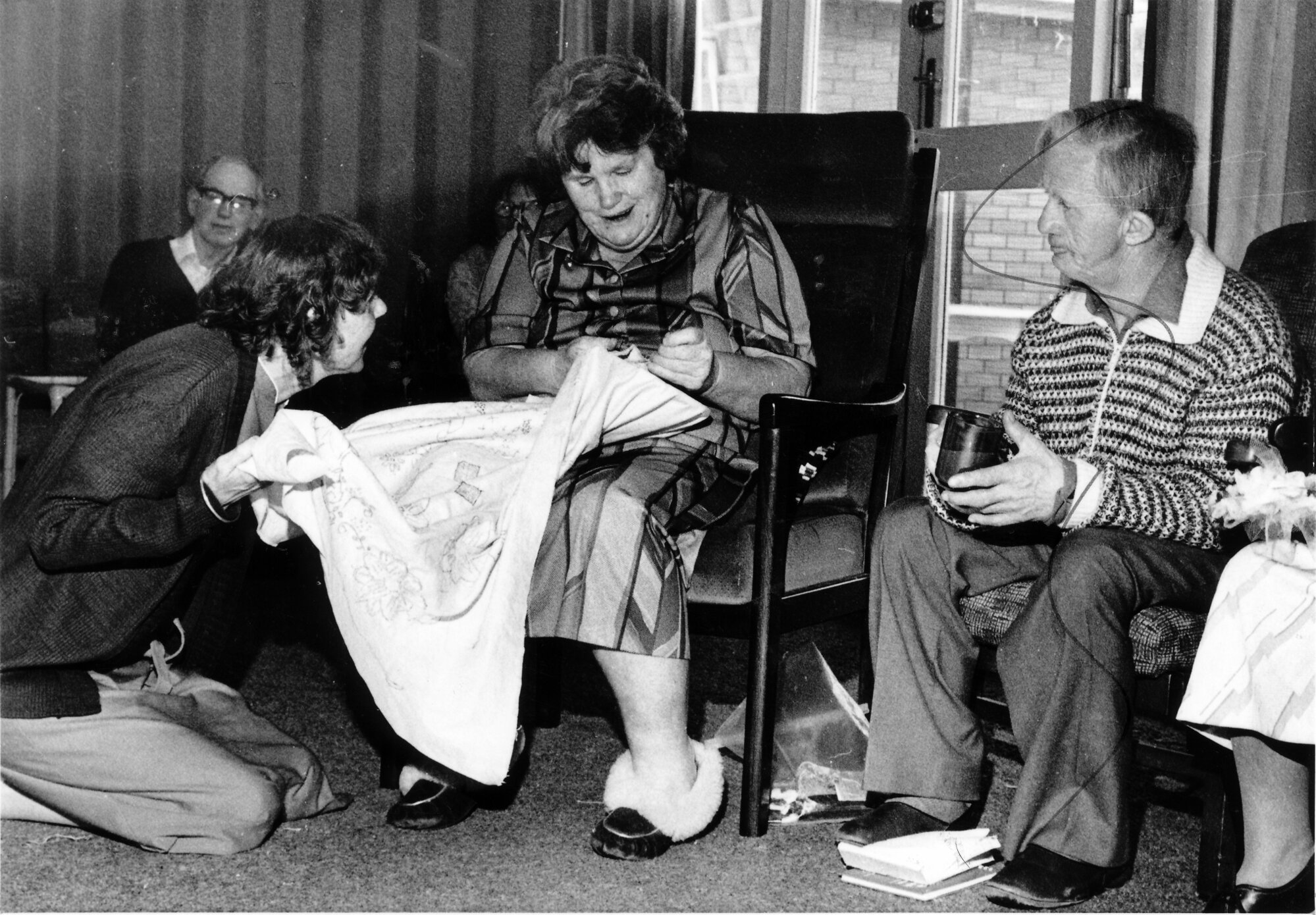 Kristina Jepsen IHC Home; Margaret admiring Isabell's embroidery; man at right not named.