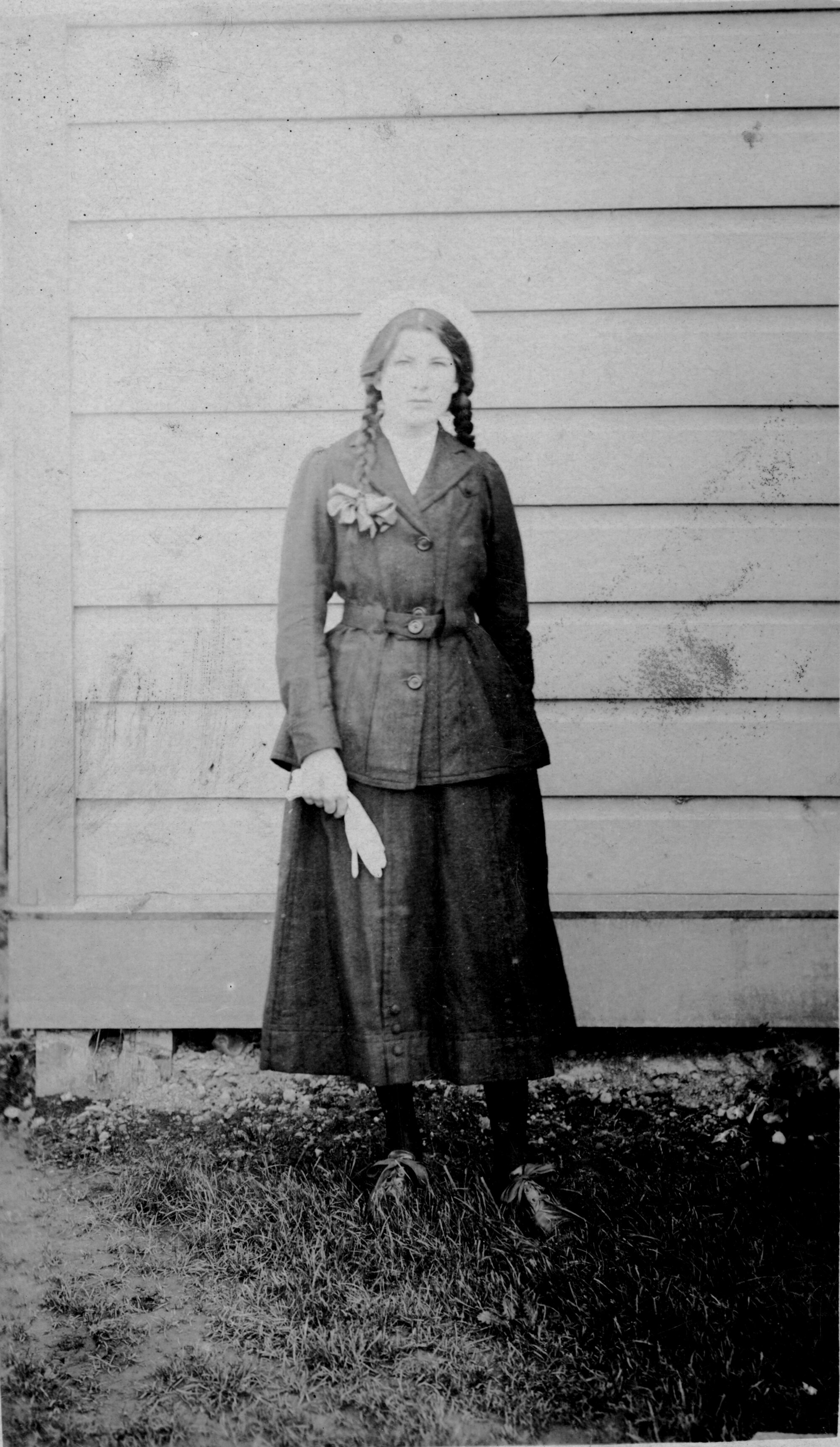 Woman; a Clifford? with plaited hair, wearing jacket, skirt, and white bonnet, and holding gloves.