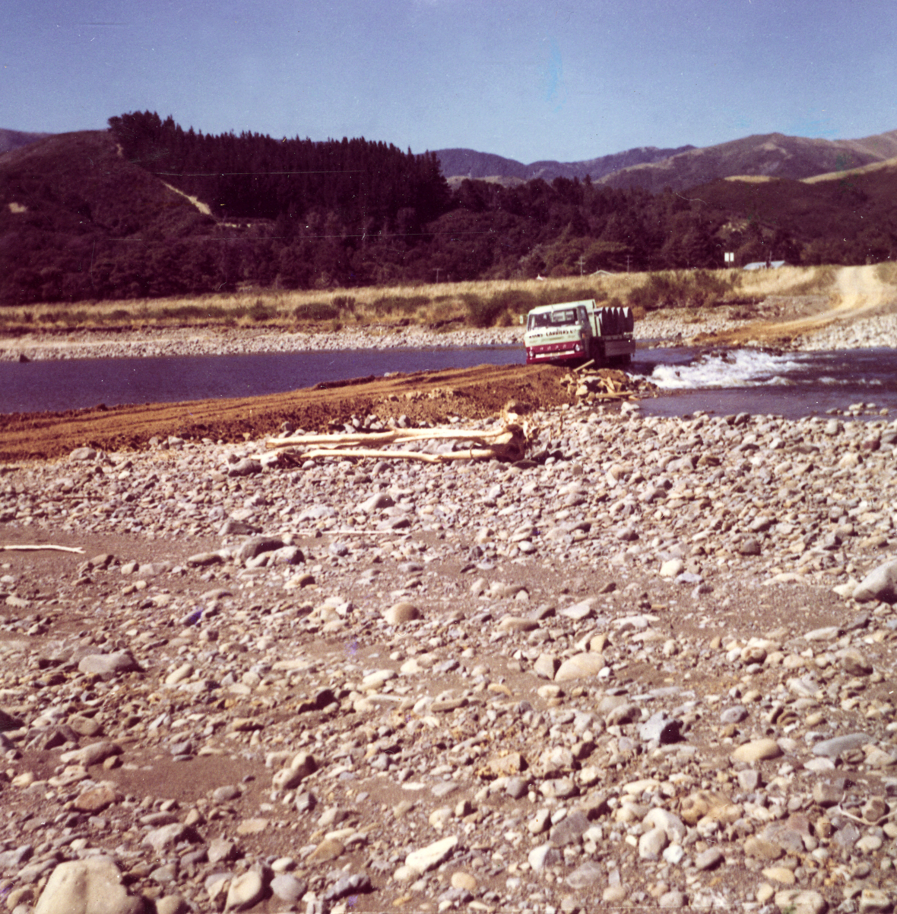 Totara Park; Truck bringing concrete pipesacross the river.