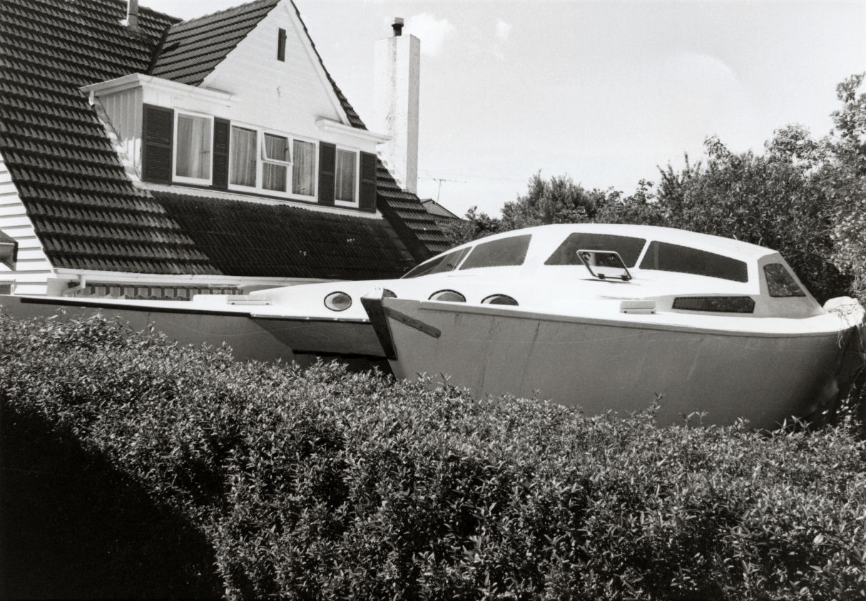 Richardsons' unfinished catamaran, seen over a neighbour's hedge.