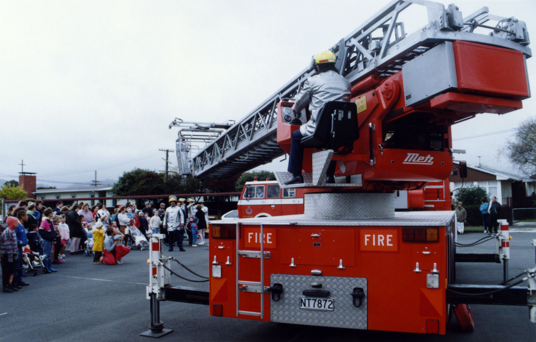 Firefighters display a turntable ladder appliance.