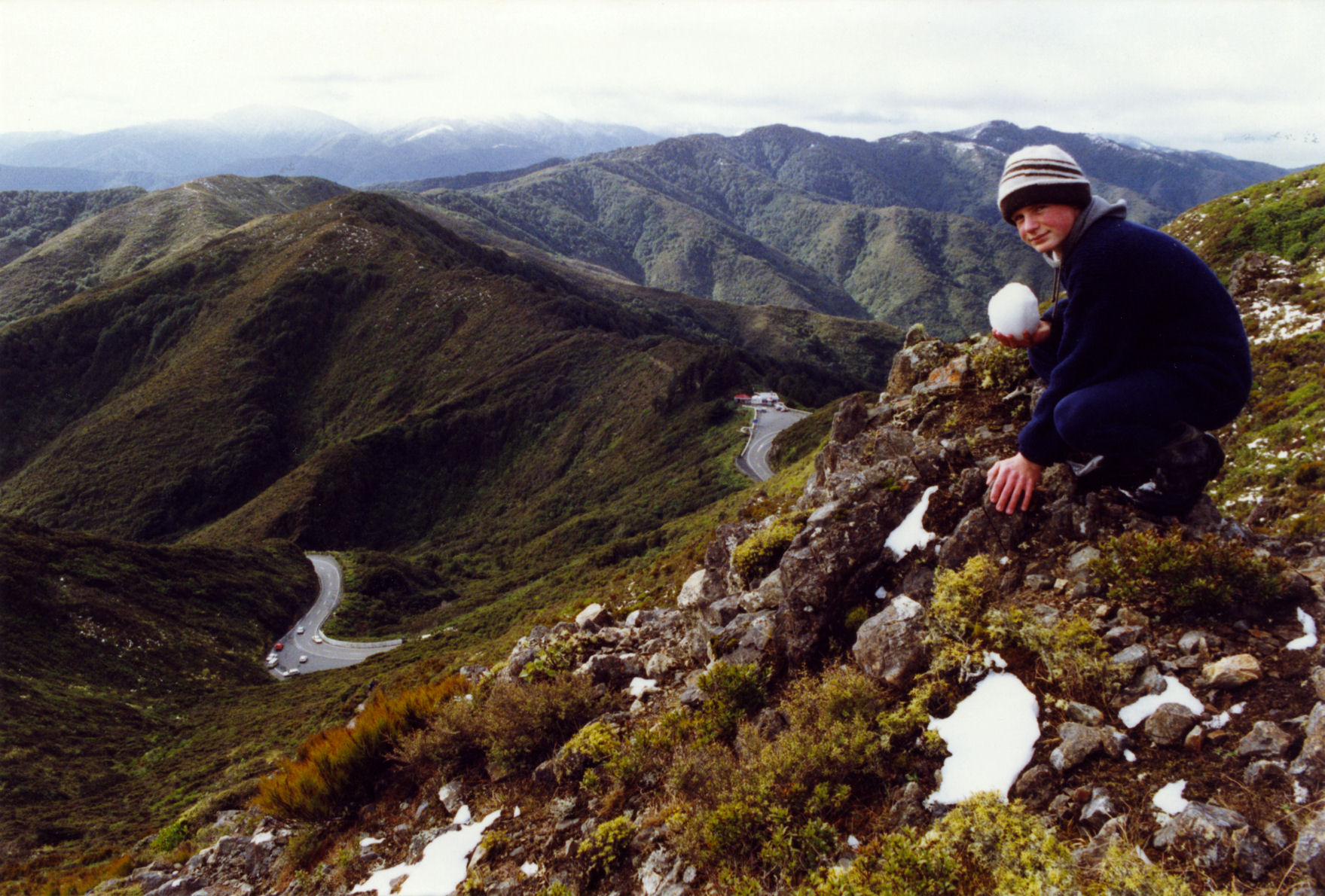 Remutaka range; Richard Westerby building a snowball on the ridge above the Summit kiosk.