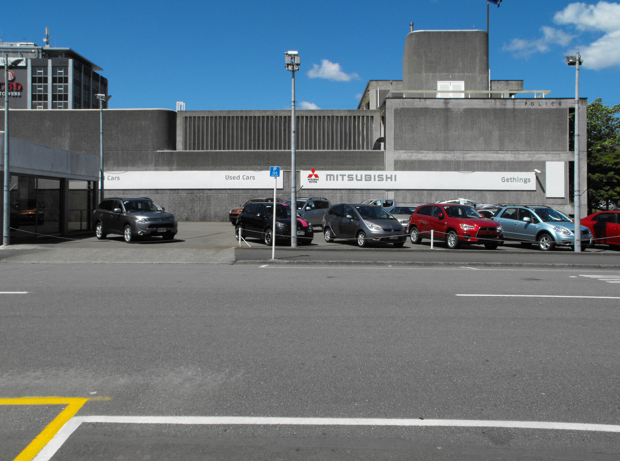 Wilson Street, east side; Gethings Mitsubishi 4; used cars; Police station in the background.