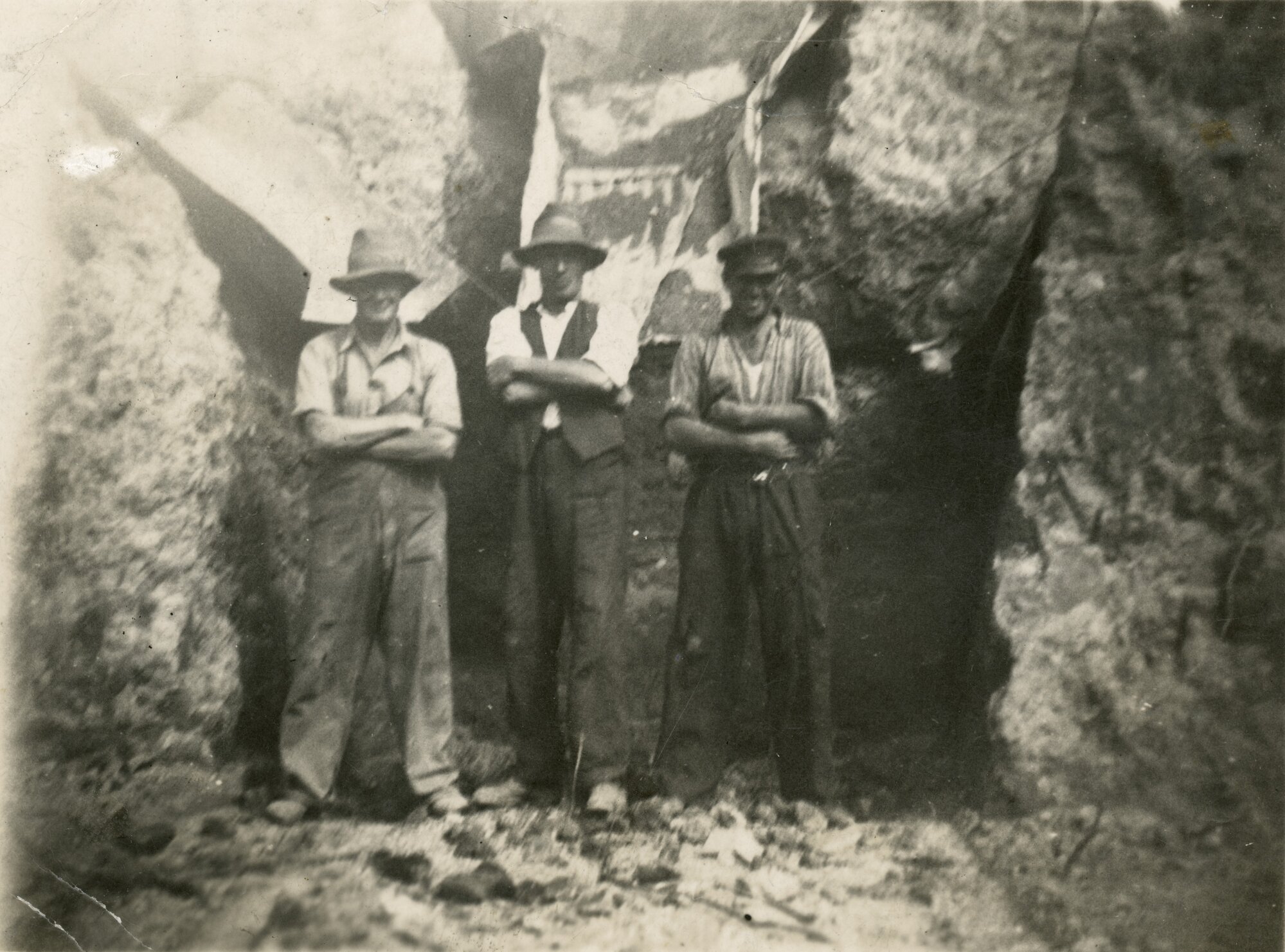 Birchville water-supply dam 2; construction, 1930. Three men in rock excavation.