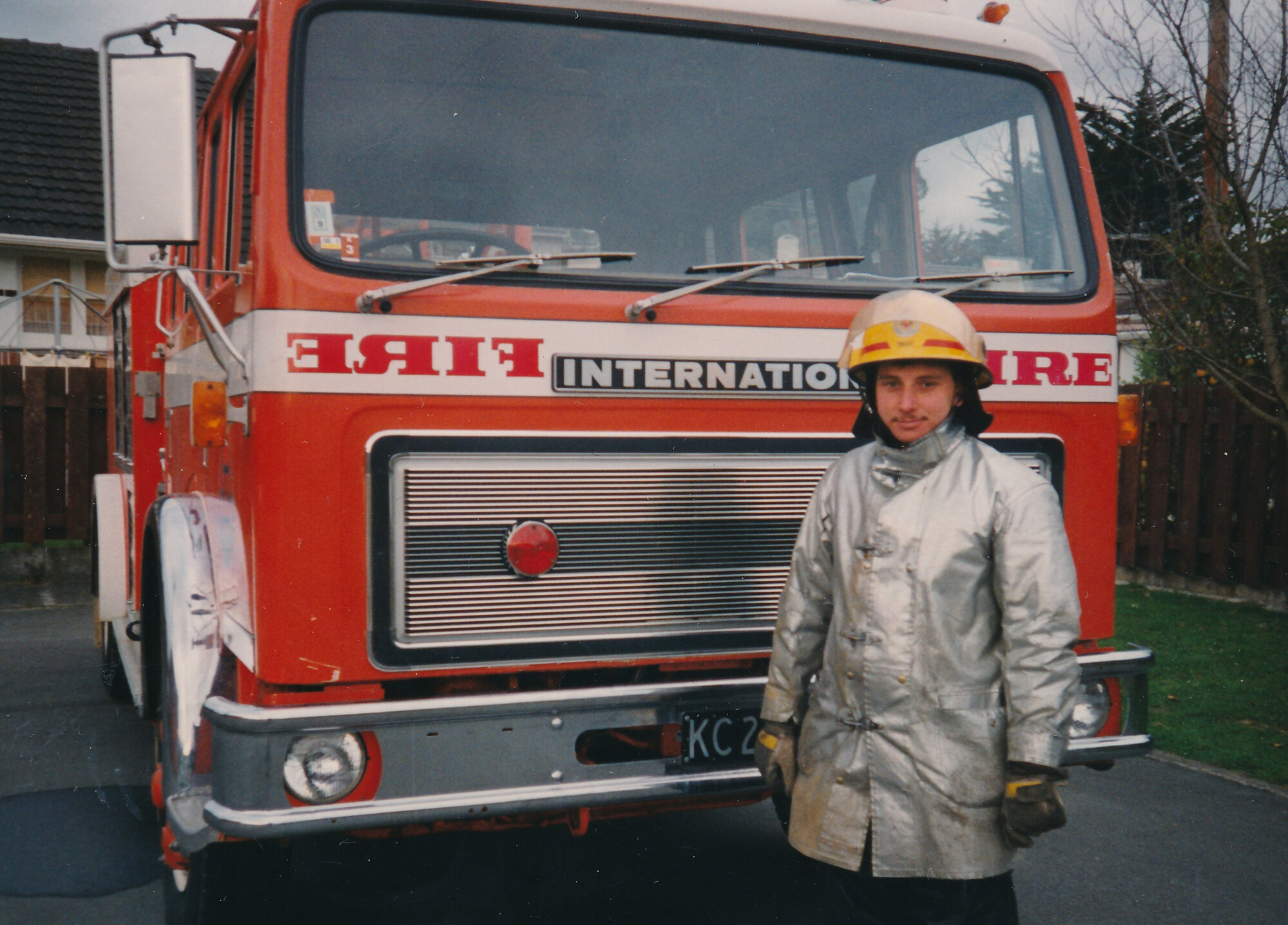 Silverstream Volunteer Fire Brigade; Firefighter Tim Rees in fire fighting gear with 'International' fire engine; circa 1990s