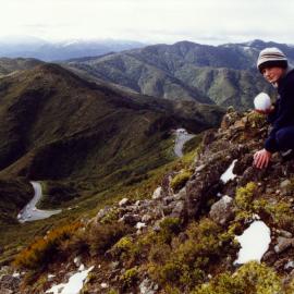 Remutaka range; Richard Westerby building a snowball on the ridge above the Summit kiosk.