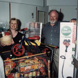 Retailers' Association; Sue Trueman, Lance Cottam with prizes for "Fill Ya Stocking Festival" draw.