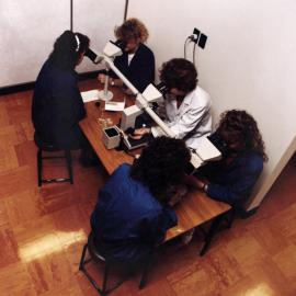 Central Institute of Technology in operation; unidentified laboratory(?); instructor with microscope sharing view with students.