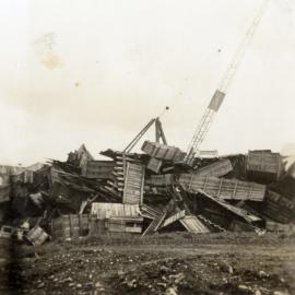 Dunlop factory construction; scrap timber; Scotch-derrick crane used in building the factory in background.