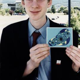 Tim McKenzie, one of six New Zealanders in Maths Olympiad, with fund-raising fractal greeting card he designed.