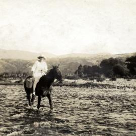 Ethel May Poulson crossing the Akatarawa River, c. 1920s