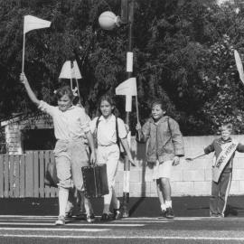 Silverstream School pupils with red pedestrian flags, crossing Fergusson Drive near the Home of Compassion.