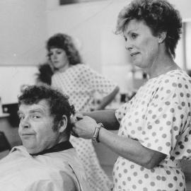 Geoffrey Hughes ('Eddie Yates' in TV's "Coronation Street") gets a haircut from Jackie Svenson of Peaches Hair Design.