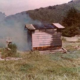 Totara Park Bridge site; old hut being burnt.