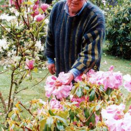 Ernie Cosgrove in his Efil Doog Garden of Art, with rhododendrons.
