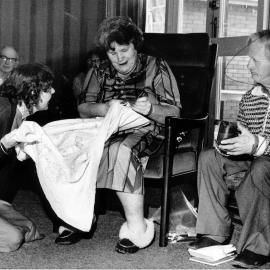 Kristina Jepsen IHC Home; Margaret admiring Isabell's embroidery; man at right not named.