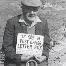 Gibb Downing with Wallaceville Valley Post Office Sign