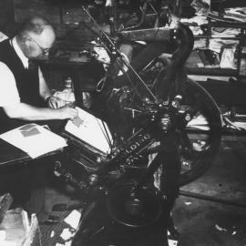 Ralph Ashford in the Upper Hutt Printing Co., with an early press.